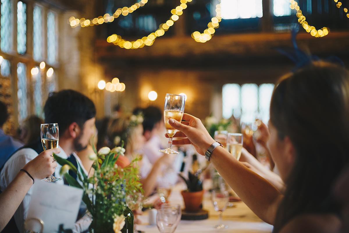 何時發送婚禮請柬:客人在婚宴上舉起酒杯歡呼
