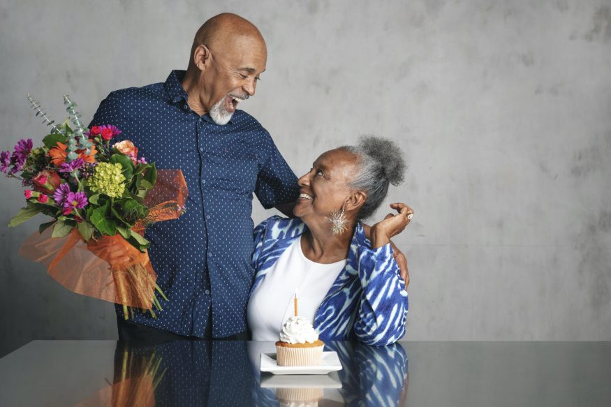 60 歲生日派對創意：男人拿著一束鮮花對著妻子微笑
