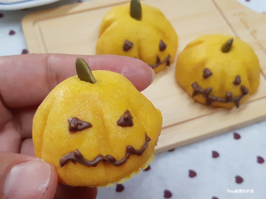 一個人手裡拿著一捧南瓜燈餅乾。